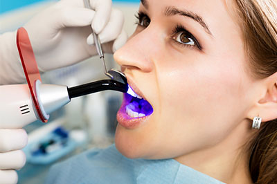 A woman receiving dental treatment with a device attached to her mouth.