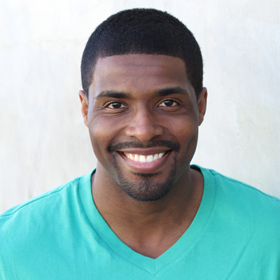 The image shows an elderly couple smiling at each other with their arms around one another, set against a scenic outdoor backdrop.