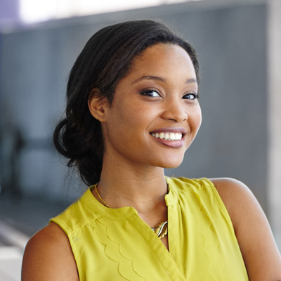 A woman with a radiant smile poses confidently against a white background.