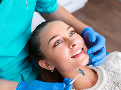 A dental professional performing a procedure on a patient s teeth.